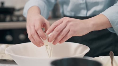 Adult Cracking Eggs Into Bowl For Baking