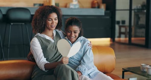 Mother and Child Admire Heart Card at Home
