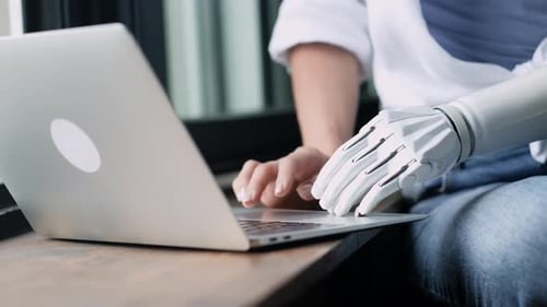 Femme motivée utilisant une prothèse de bras pour travailler ou apprendre, ordinateur portable, fille handicapée