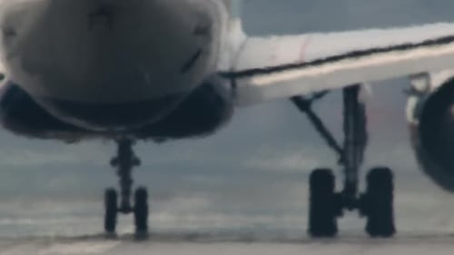 Close-up of Back of Airplane Taxiing Down Runway and Taking Off
