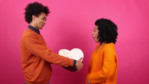 Man Giving Heart Gift to Delighted Woman