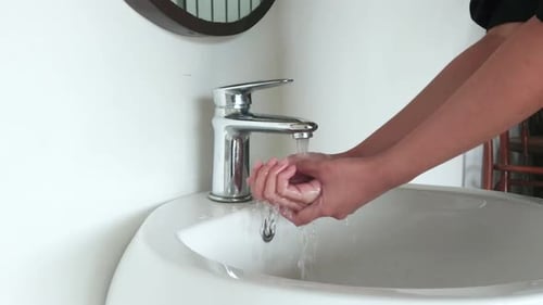 Washing hand in a sink to wash the skin and water flows through the hands. Concept of health, cleani