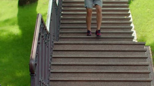 Man Running Down Stairs. Fitness Man Running Downstairs in Park. Man Jogging
