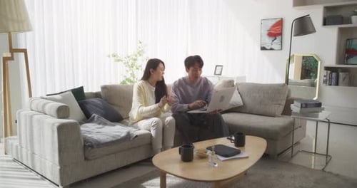 Couple Using Laptop Together on Couch at Home