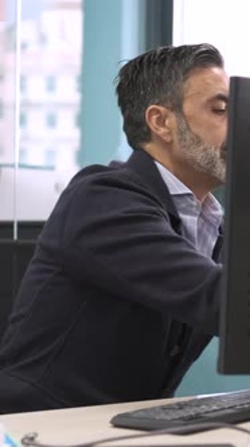 Man Typing at Computer in Bright Office