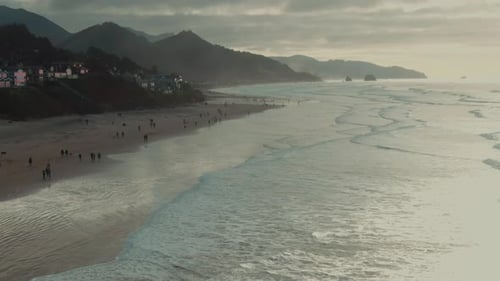 4k aerialOregon coast with people walking on the beach Drone dolly in