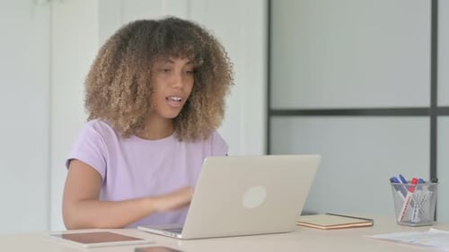 Woman Talking on a Laptop in the Office