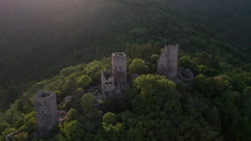 Aerial view of castle ruins in forest and mountains, France.