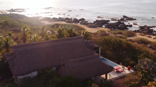 Fast drone pan around luxury oceanfront rental villa in Oaxaca Mexico Pacific Ocean sunrise 4k aeria