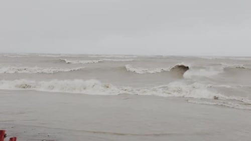 The Scenery of Intense Waves Splashing Gently Onto The Shore During Rainy Day - Medium Shot