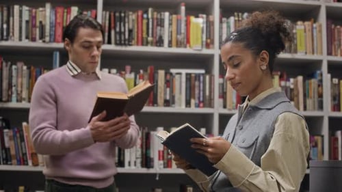 Motivated Multiethnic Students Reading Books in front of Library Shelf