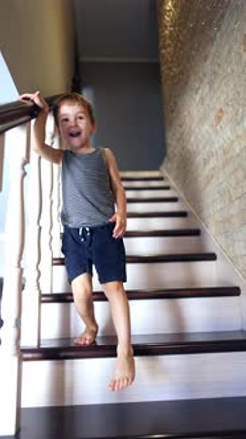 Smiling Boy Walking Down Stairs at Home