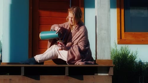Woman Drinks Mate Tea and Enjoys Sunrise on the Wooden Terrace