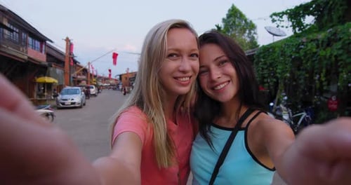 Happy young women loving couple take photos in ko lanta Thailand old town