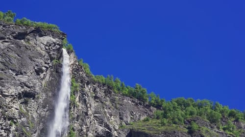 A breathtaking view of the waterfall in Geiranger fjord, Norway. A powerful stream of water falling
