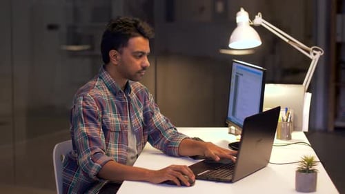 Technology, Deadline and People Concept - Programmer with Laptop Computer Working At