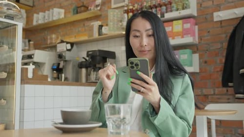 Stylish Woman Using Smartphone While Sitting With Coffee In Modern Cozy Cafe