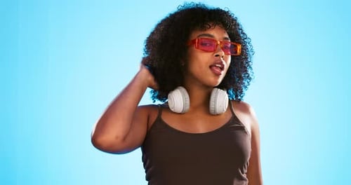Face wink, sunglasses and hair care of woman in studio isolated on a blue background