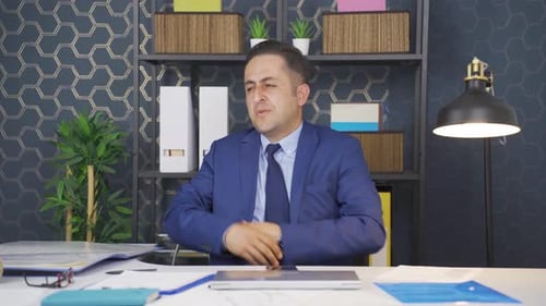 Man Massaging Neck at Office Desk