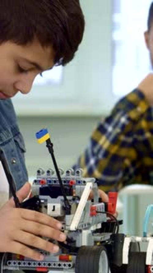 Junge konzentriert sich darauf, ein Spielzeugauto zu bauen, während sein Vater vor Stolz strahlt