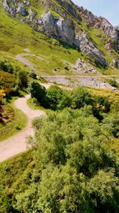 Ground road in the picturesque mountains. Stunning rocky landscape on sunny day. Aerial view.