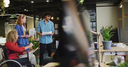 Happy disabled and diverse business people discussing work at office