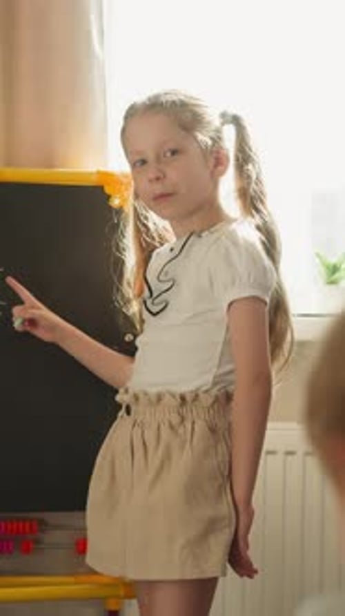 Young Girl Doing Math at Chalkboard