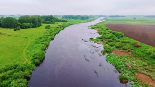 Overcast Drone View of Lielupe River Meandering Through Latvian Farmland Scene