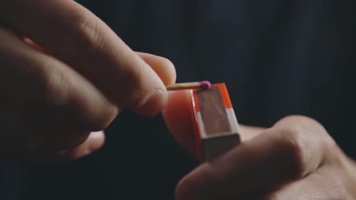 Hands Strike A Match On The Box With Sparks - close up