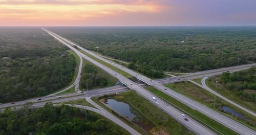 Elevated View of Freeway Exit Junction Over Road Lanes with Fast Moving Traffic Cars and Trucks at