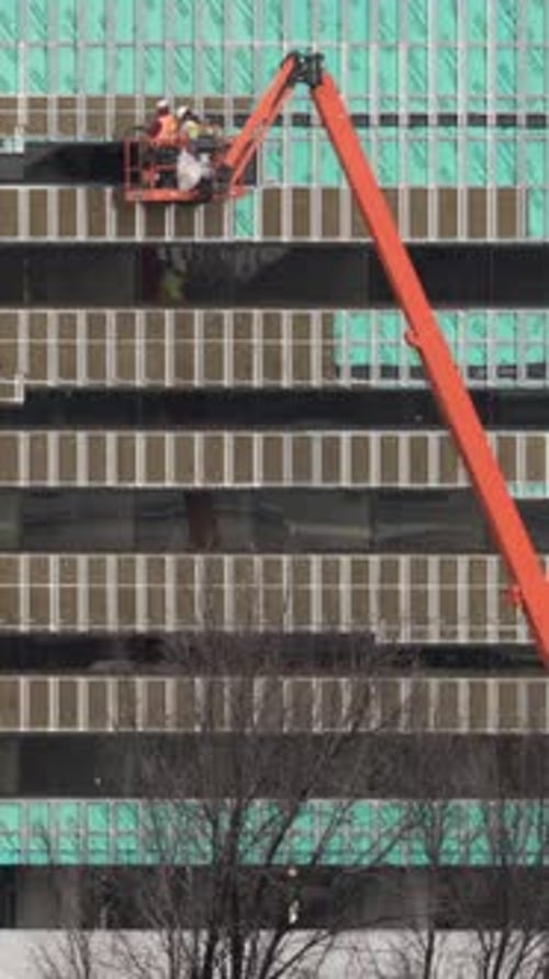 Vídeo vertical de trabajadores de la construcción en elevadores
