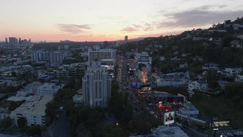 Aerial View of Buildings and Large Advertisements in City Against Colourful Twilight Sky Heavy