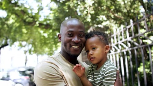 Father with His Son on Walk in Public Park