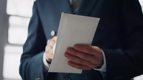 Hombre elegante desconocido tomando dinero en efectivo de un sobre de papel en interiores de cerca