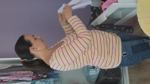 Woman Sorting Through Clothing in Open Drawer