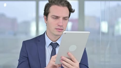 Portrait of Young Businessman using Tablet in Modern Office