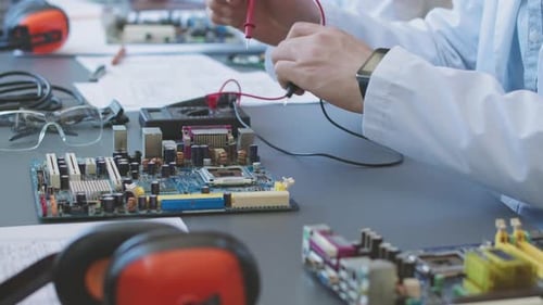 Technicians Testing Computer Circuit Board at Workplace