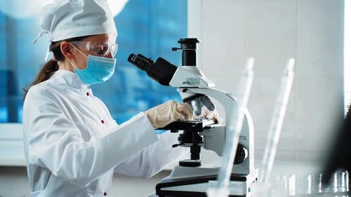 Medical Professional Analyzes Samples Under Microscope