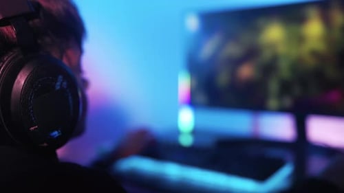 Gamer Playing Video Game with Headphones at Night
