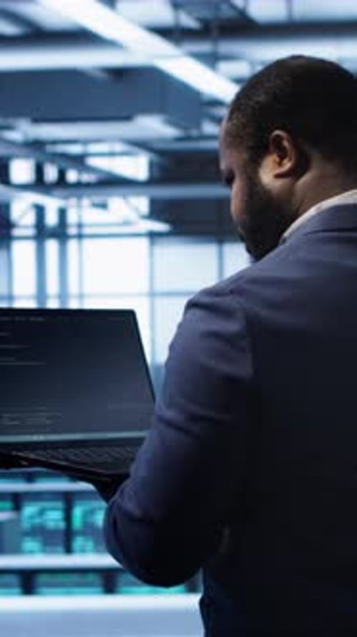 Vertical Video Computer Scientist in Server Farm Using Laptop to Patch Network Issues