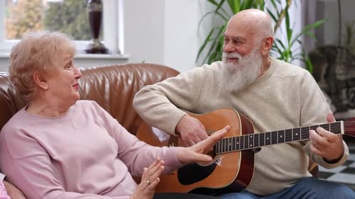 Happy Senior Couple Playing Guitar and Singing