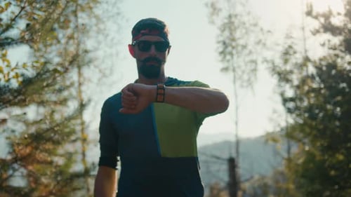 Adult Man Checks Watch During Forest Run