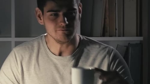 Man Works at Computer, Rubs Eyes, Drinks Coffee