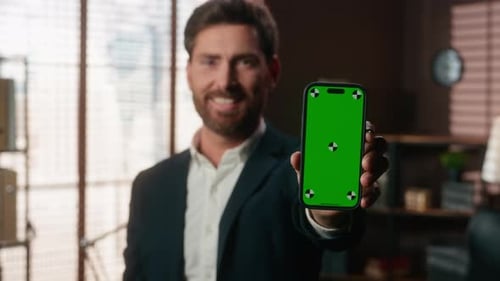 Smiling Caucasian Middleaged Business Man Showing Mobile Phone with Green Chroma Key Screen Cheerful