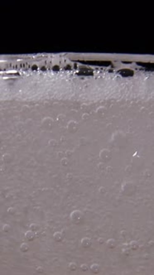 Bubbles Filling Glass Close Up on Black Background