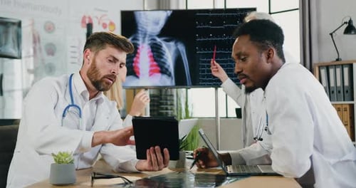 Doctors talking between themselves during joint meeting in clinic office. Medical concept