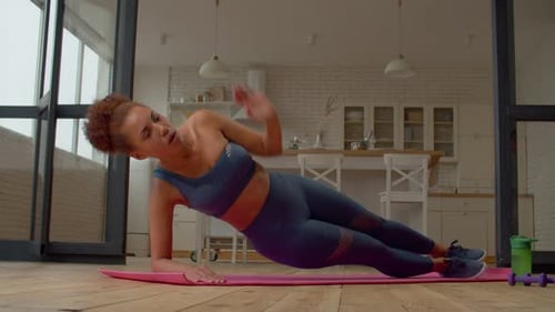 Active Sporty Fit African Woman Practicing Side Plank Yoga Exercise Indoors