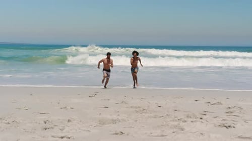 Young male friends running towards sea 4k
