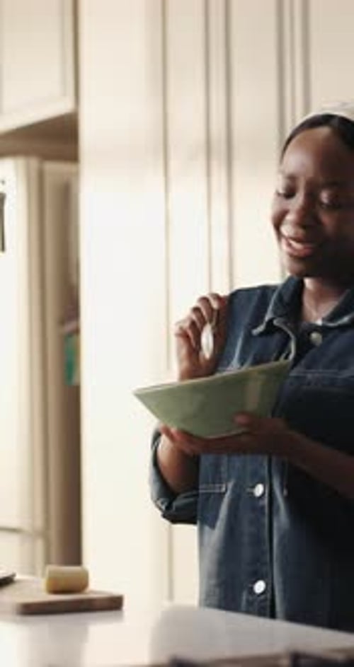 Smiling Woman Mixing Ingredients in a Kitchen Bowl