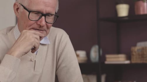 Senior Man Concentrating While Playing Chess at Home